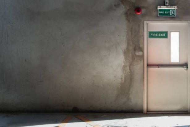 What is the minimum time an NHS fire door will contain fire smoke and toxic fumes