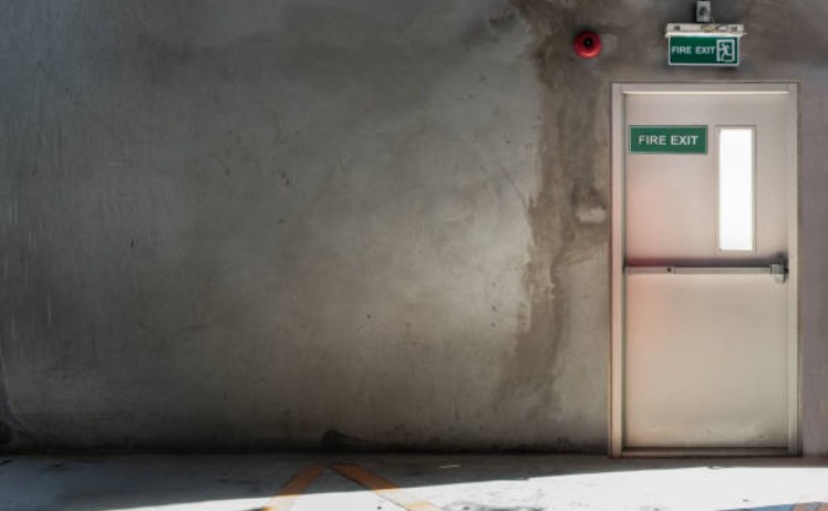 What is the minimum time an NHS fire door will contain fire smoke and toxic fumes