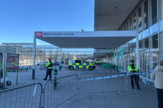 Police presence outside Milton Keynes Central station following a fatal shooting involving an armed suspect.