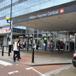 Police officers at Milton Keynes railway station cordon off area following a fatal shooting incident involving an armed suspect.