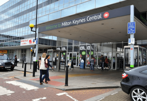 Police officers at Milton Keynes railway station cordon off area following a fatal shooting incident involving an armed suspect.
