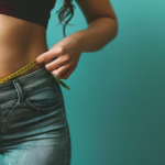 Woman measuring her belly with measuring tape.