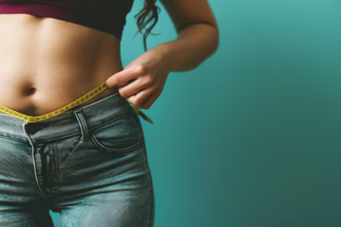 Woman measuring her belly with measuring tape.